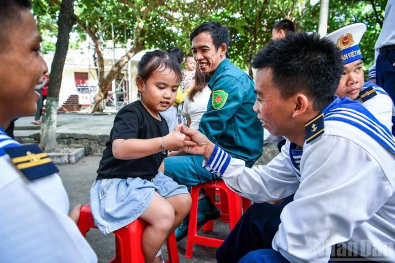 Những lúc rảnh, những anh lính trẻ chơi đùa cùng các em bé trên đảo để vơi đi nỗi nhớ nhà.