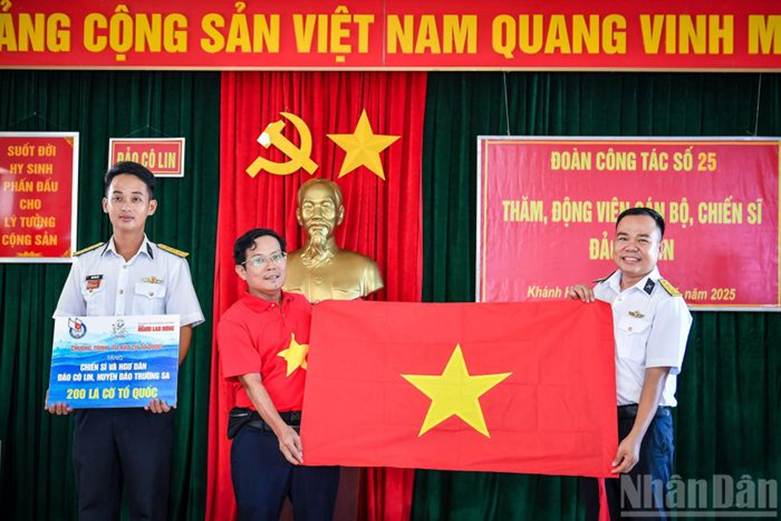 Nhà báo Tô Đình Tuân, Tổng Biên tập Báo Người Lao Động trao cờ Tổ quốc từ chương trình Tự hào cờ Tổ quốc đến các chiến sĩ và ngư dân.