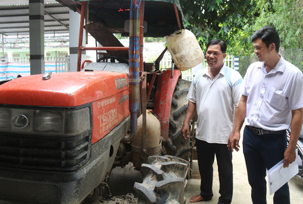 Ông Kim Yên (bên trái) trao đổi với cán bộ Hội Nông dân xã Tập Sơn về mô hình cơ giới hóa nông nghiệp. Ảnh: SU CHỊA

