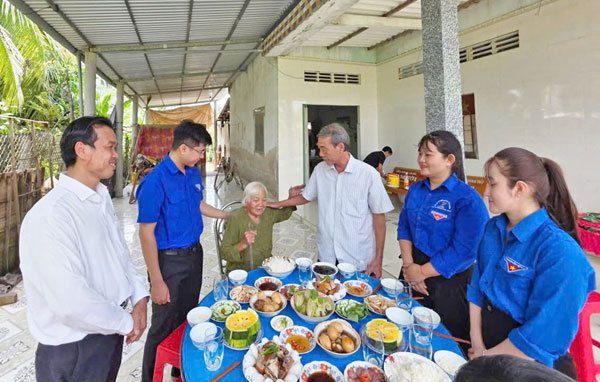 Đoàn viên, thanh niên xã Mỏ Cày tổ chức “Bữa cơm nghĩa tình” tại nhà mẹ Nguyễn Thị Xa.Ảnh: NGỌC XOÀN