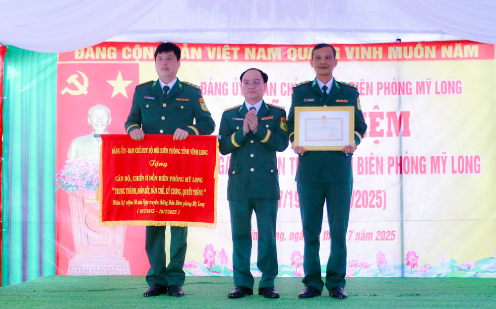 Đại tá Nguyễn Hồng Lượng- Phó Chỉ huy trưởng Ban Chỉ huy BĐBP tỉnh trao bức trướng và trao khen thưởng cho cán bộ, chiến sĩ Đồn Biên phòng Mỹ Long.