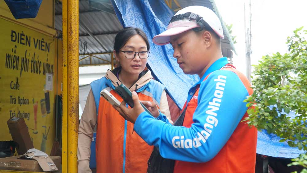 Chị Trần Diễm My hướng dẫn đồng nghiệp giải quyết đơn hàng trên ứng dụng của công ty.

