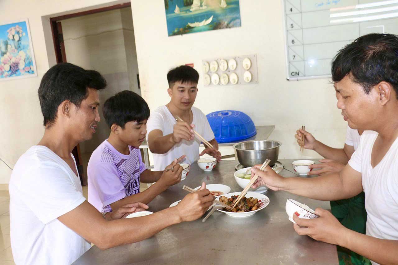 Em Nguyễn Văn Tài, được các cha nuôi chăm chút trong bữa ăn.