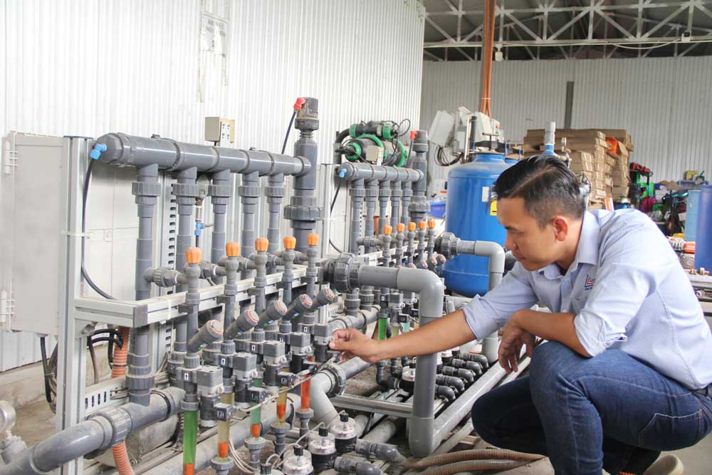 Anh Lộc kiểm tra hệ thống máy móc đang vận hành, cung cấp dinh dưỡng cho khu vườn.