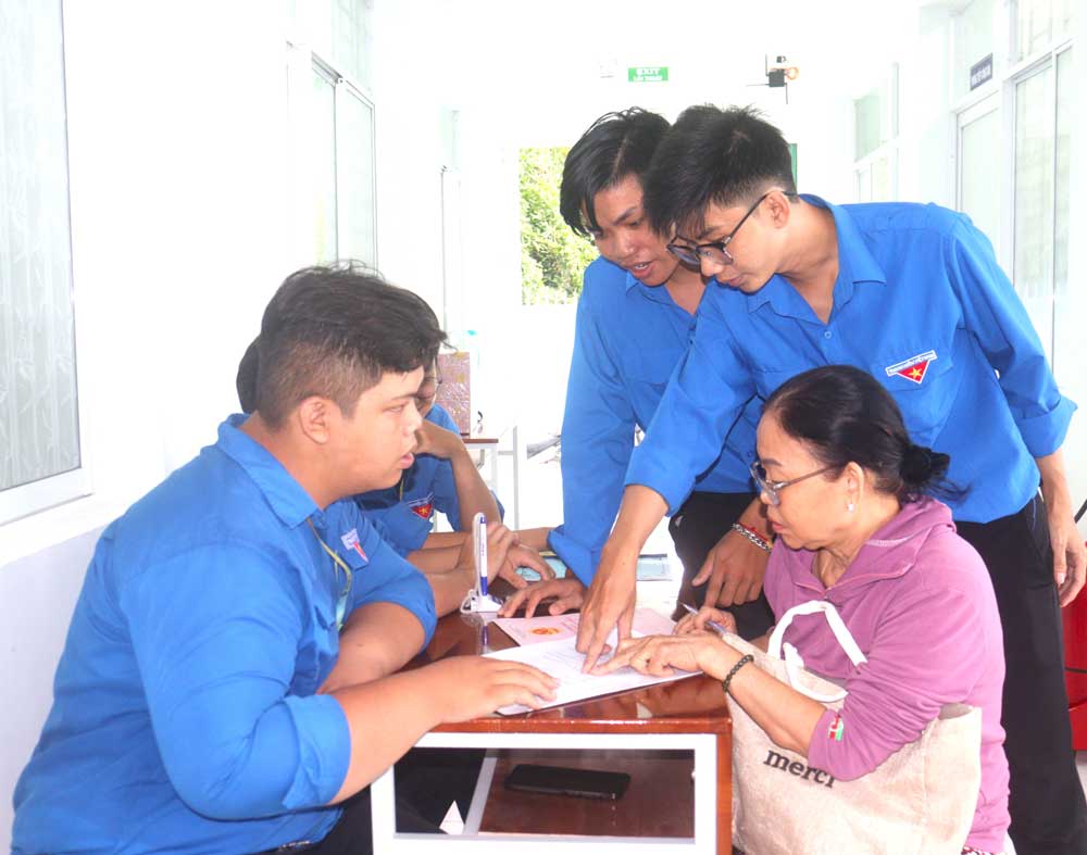Chiến sĩ mùa hè xanh hỗ trợ người dân khi đến trung tâm phục vụ 
hành chính công thực hiện thủ tục hành chính.