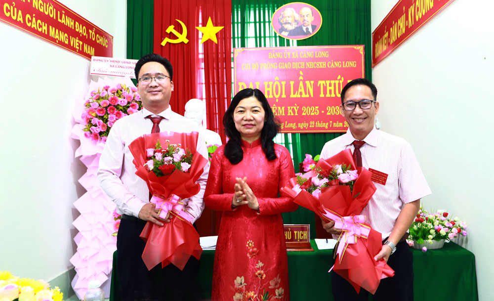 Đồng chí Trần Thị Bích Phượng- Tỉnh ủy viên, Bí thư Đảng ủy xã Càng Long tặng hoa chúc mừng Bí thư (bên phải) và Phó Bí thư Chi bộ Phòng Giao dịch Ngân hàng NHCSXH Càng Long nhiệm kỳ 2025 - 2030.