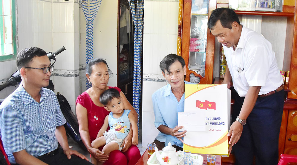 Đồng chí Kim Rương- Ủy viên Ban Thường vụ Tỉnh ủy tặng quà cho gia đình ông Nguyễn Ngọc Nam (ấp Giữa, xã Vinh Kim). Ảnh Mỹ Nhân