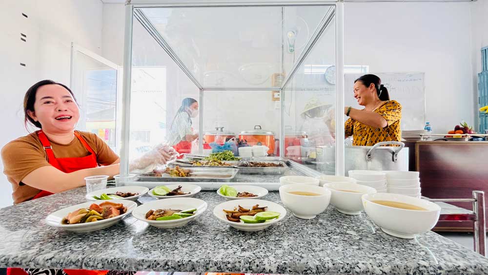 Các thành viên ban điều hành “Bếp cơm 0 đồng” vui vẻ phục vụ người đến ăn cơm, có món chay và món mặn, đảm bảo dinh dưỡng, an toàn thực phẩm.