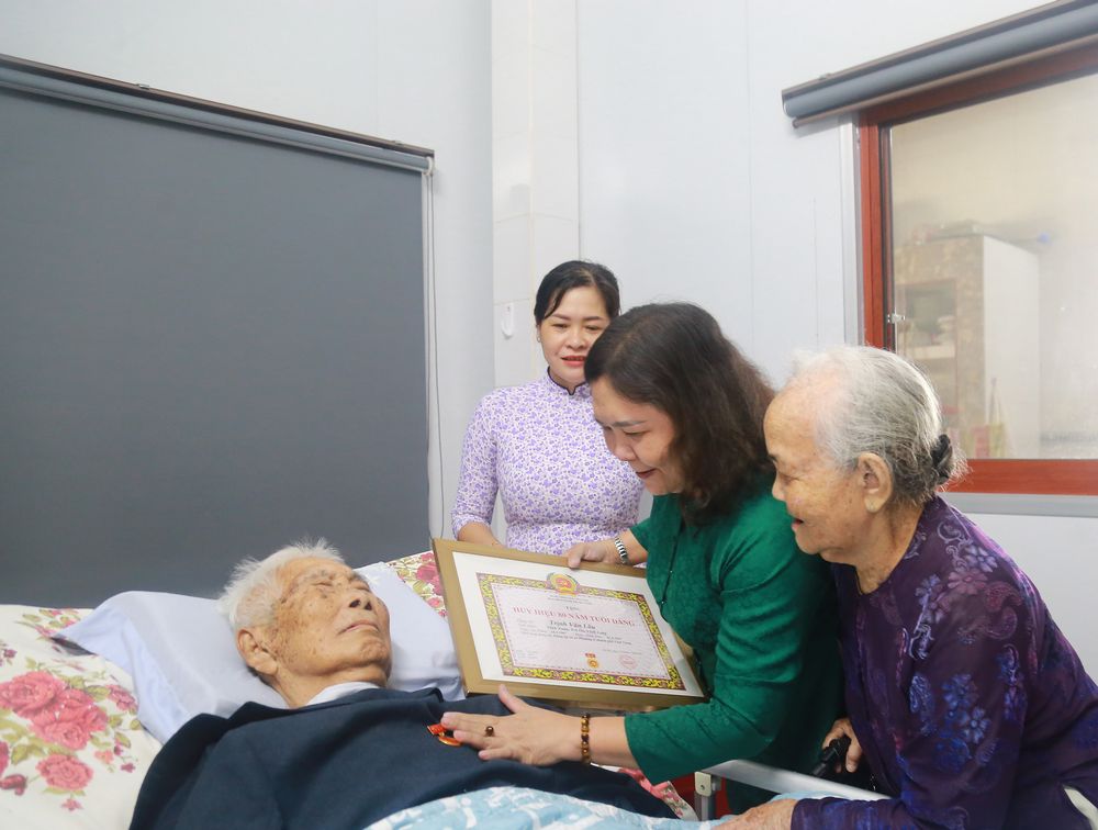 Phó Bí thư Thường trực Tỉnh ủy- Hồ Thị Hoàng Yến trao tặng đồng chí Trịnh Văn Lâu Huy hiệu 80 năm tuổi Đảng.