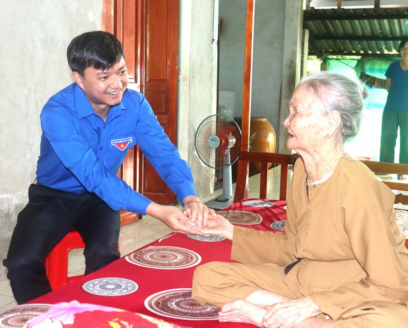 Anh Nguyễn Minh Triết- Bí thư Trung ương Đoàn ân cần thăm hỏi sức khỏe Mẹ Việt Nam anh hùng Lê Thị Liên.