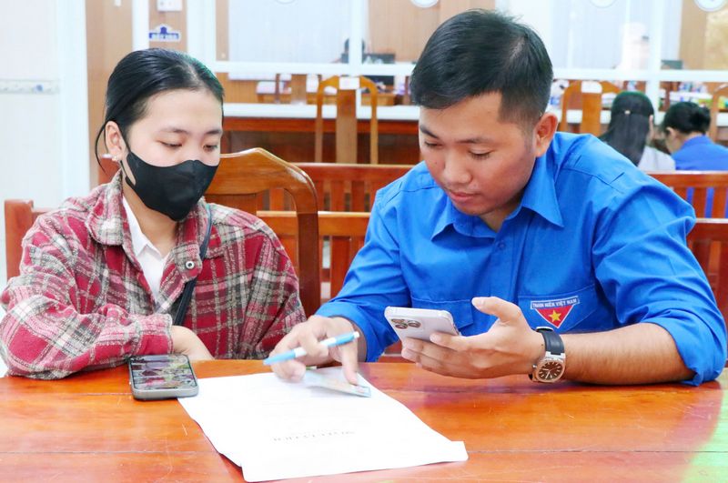 Đảng viên trẻ Thạch Minh Mẫn hỗ trợ người dân nộp hồ sơ trực tuyến.