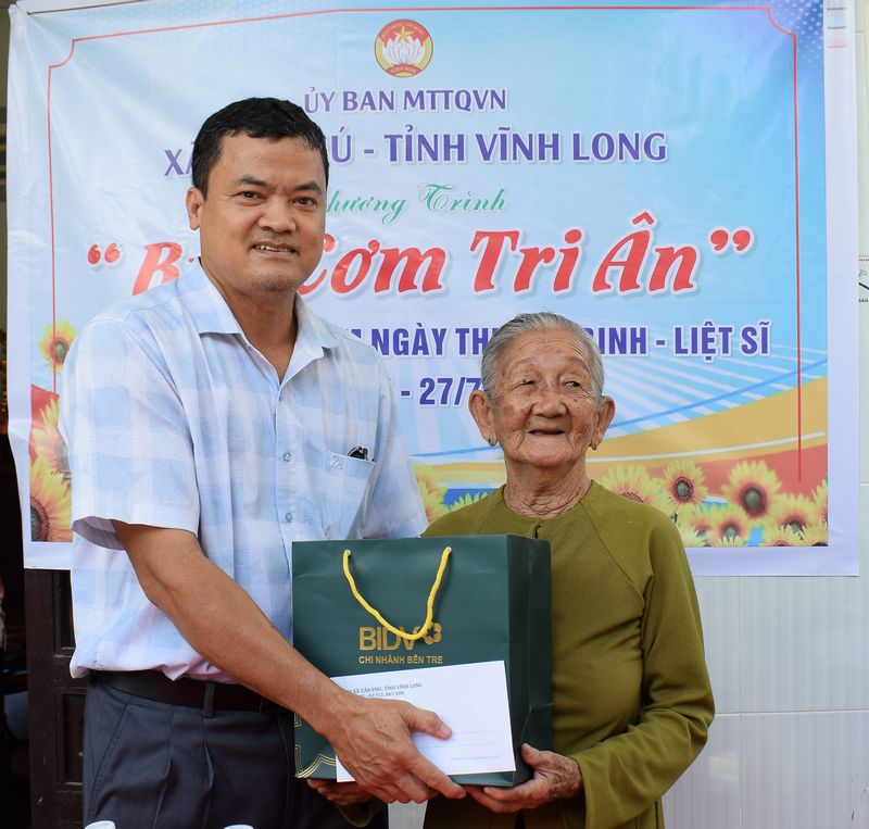 Đồng chí Huỳnh Thanh Vũ- Phó Bí thư Thường trực Đảng ủy xã Tân Phú tặng quà cho bà Hồ Thị Năm (vợ liệt sĩ).