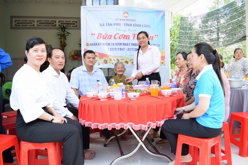 Cán bộ, đoàn thể xã cùng bà Hồ Thị Năm dùng cơm trong không khí ấm áp như gia đình.