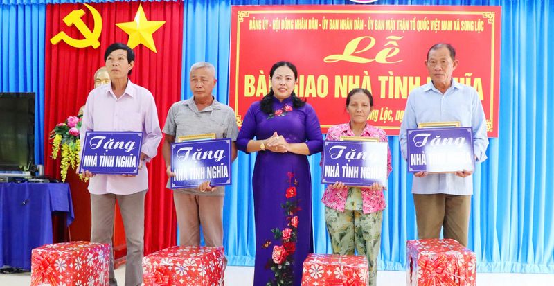 Đồng chí Tô Thị Thu Hồng- Bí thư Đảng ủy xã Song Lộc trao bảng tượng trưng bàn giao nhà tình nghĩa cho các gia đình.