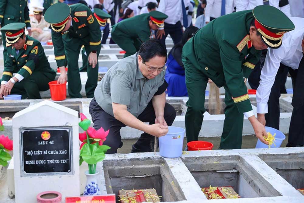 Thủ tướng Phạm Minh Chính cùng đoàn công tác thực hiện nghi lễ an táng hài cốt liệt sĩ tại Nghĩa trang liệt sĩ Dốc Bà Đắc - Ảnh: VGP/Nhật Bắc
