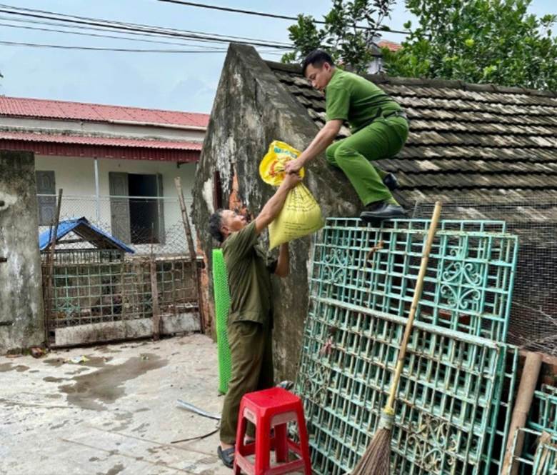 Lực lượng công an giúp đỡ người dân chằng chống nhà cửa.