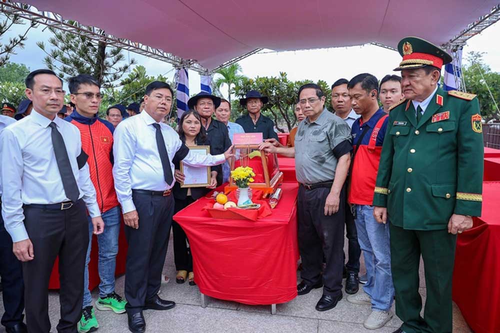 Thủ tướng chia sẻ với gia đình liệt sĩ Ngô Văn Liên tại Lễ truy điệu và an táng hài cốt liệt sĩ tại Nghĩa trang liệt sĩ Dốc Bà Đắc - Ảnh: VGP/Nhật Bắc
