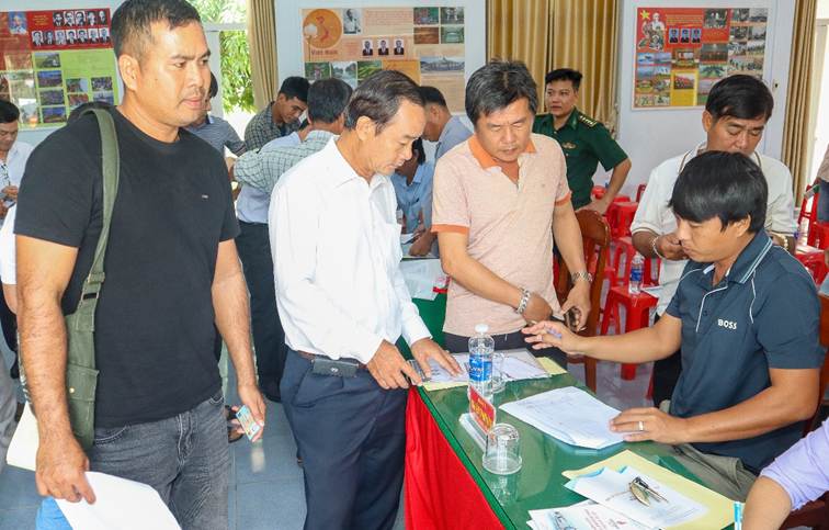 Đồng chí Huỳnh Hoàng Thành - Phó Giám đốc Sở Khoa học và Công nghệ tỉnh Vĩnh Long (áo trắng) hướng dẫn ngư dân hoàn thiện hồ sơ đăng ký giấy phép sử dụng tần số, thiết bị vô tuyến điện trên tàu cá.