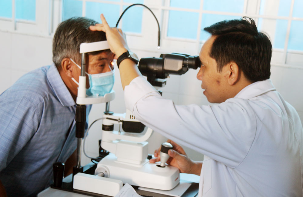 Bác sĩ Bệnh viện Mắt Sài Gòn Vĩnh Long khám mắt cho người cao tuổi là người có công với cách mạng tại chương trình khám, cấp thuốc miễn phí ở xã Song Lộc.