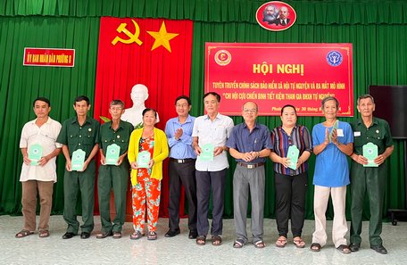 Ông Ngô Tuấn Anh- Phó Giám đốc BHXH tỉnh và ông Nguyễn Thanh Bình- Phó Chủ tịch Hội CCB tỉnh trao sổ tiết kiệm cho các thành viên.