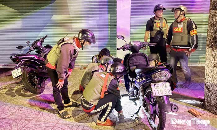 Các thành viên Câu lạc bộ “Anh em SOS Lấp Vò – Đồng Tháp” giúp người đi đường sửa xe trong đêm.
