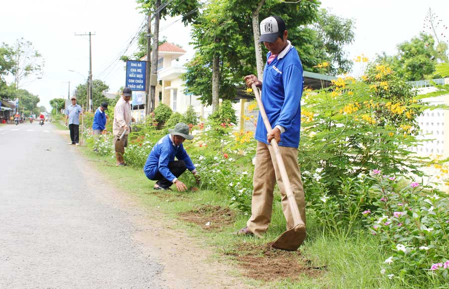 Đảng viên Ấp Chợ, xã Long Hiệp ra quân làm vệ sinh, chăm sóc tuyến đường hoa, góp phần bảo vệ môi trường xanh, sạch, đẹp.