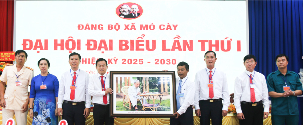 Đồng chí Kim Rương- Ủy viên Ban Thường vụ Tỉnh ủy tặng bức tranh Chủ tịch Hồ Chí Minh cho Đảng bộ xã Mỏ Cày.