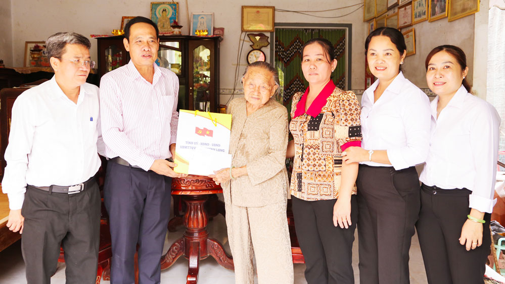 Đồng chí Trịnh Minh Hùng- Phó Giám đốc Sở Nội vụ tặng quà Mẹ Việt Nam anh hùng Lê Thị Tuyết (ấp Ba Tục A, xã Trà Cú). Ảnh: Ngọc Xoàn
