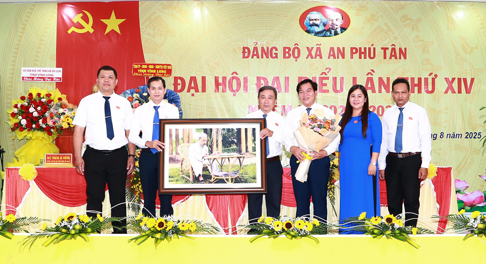 Đồng chí Dương Hoàng Sum (thứ ba, phải sang)- Tỉnh ủy viên, Giám đốc Sở Văn hóa, Thể thao và Du lịch tặng bức ảnh chân dung Chủ tịch Hồ Chí Minh cho đại hội. Ảnh: Kim Loan