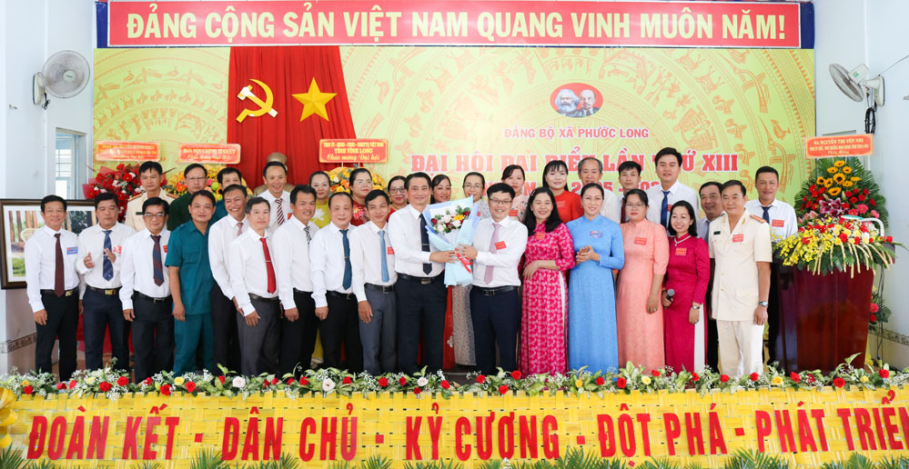 Đồng chí Nguyễn Quỳnh Thiện- Tỉnh ủy viên, Phó Chủ tịch UBND tỉnh tặng hoa chúc mừng BCH Đảng bộ xã Phước Long, nhiệm kỳ 2025 - 2030. Ảnh: Diệu Hiền.
