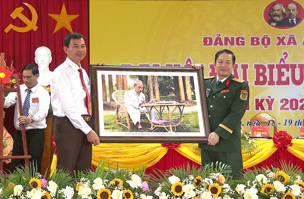 Đồng chí Trần Minh Trang- Ủy viên Ban Thường vụ Tỉnh ủy, Chỉ huy trưởng Bộ Chỉ huy Quân sự tỉnh trao tặng đại hội bức ảnh Chủ tịch Hồ Chí Minh. Ảnh: Nguyễn Xuân