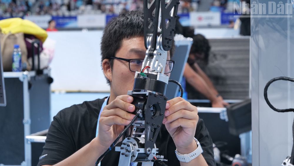  Kỹ thuật viên hiệu chỉnh bộ phận của vận động viên robot hình người.