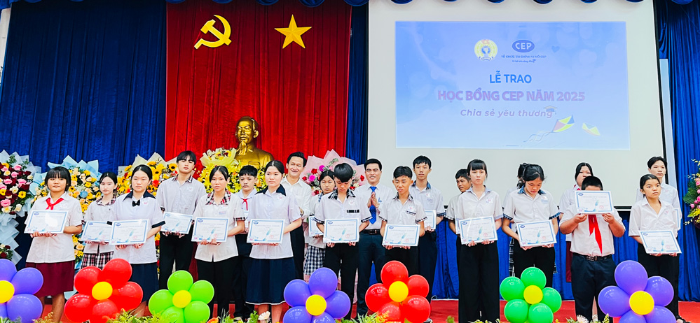 Ông Nguyễn Trung Cang - Giám đốc Tổ chức Tài chính vi mô CEP chi nhánh Vĩnh Long và ông Đoàn Văn Huệ - Chủ tịch UBND phường Long Châu trao học bổng cho các em học sinh.
