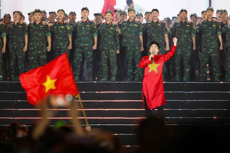 
Ca sĩ Tùng Dương mang đến niềm xúc động và tự hào trào dâng với ca khúc Tiến quân ca. Dàn đại hợp xướng của 200 nghệ sĩ và hơn 30.000 khán giả cùng hòa giọng đã nâng cánh cho giọng hát khỏe khoắn, hào sảng của Tùng Dương đi sâu vào tâm thức người nghe