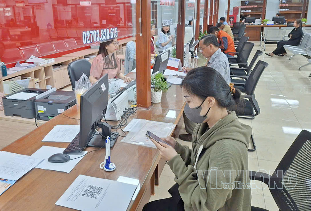 Nhân viên BHXH tỉnh hướng dẫn người dân hoàn tất thủ tục để hưởng chế độ BHXH tại Trung tâm Phục vụ hành chính công tỉnh.