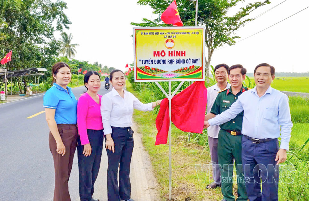 Đồng chí Lê Thanh Bình- Bí thư Đảng ủy, Chủ tịch HĐND xã Trà Cú (bìa phải) dự ra mắt mô hình “Tuyến đường rợp bóng cờ bay” trên địa bàn xã.


