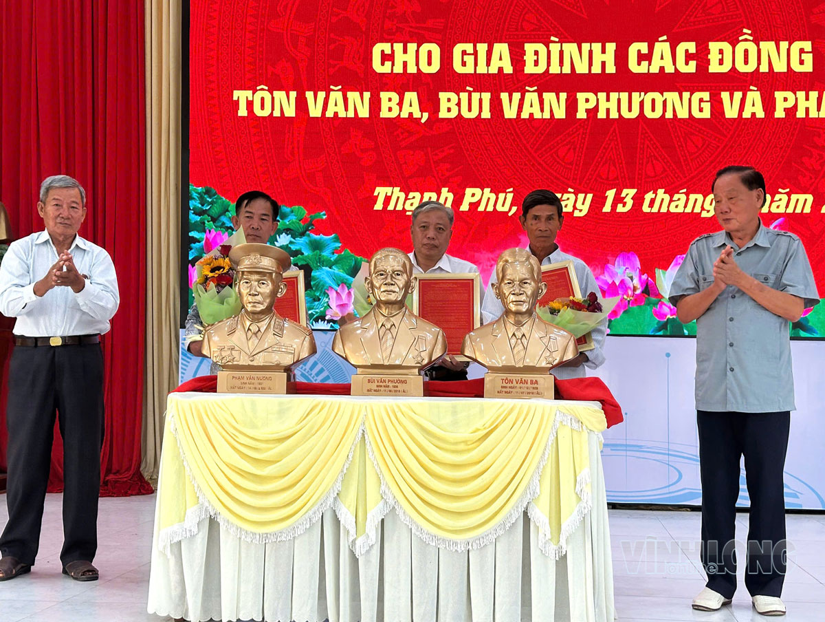 Đồng chí Huỳnh Văn Be (bên phải) trao tặng tượng đồng cho các gia đình.