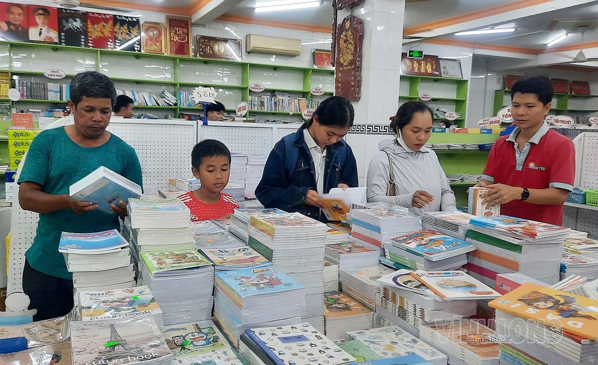 Phụ huynh, học sinh chọn mua SGK tại nhà sách ở phường Nguyệt Hóa.