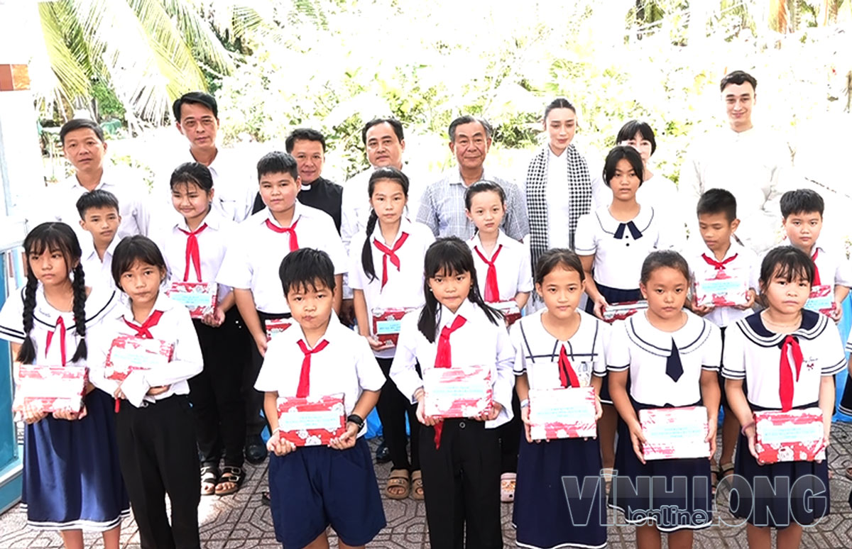 Đại biểu tặng quà và chụp ảnh lưu niệm với các em học sinh.