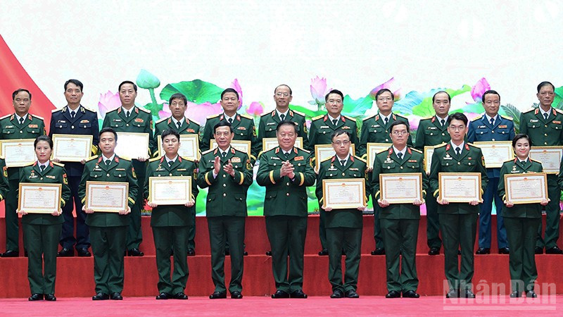 Các đồng chí Phan Văn Giang, Nguyễn Trọng Nghĩa (lần lượt thứ 4 và 5 từ trái sang, hàng đầu) trao Bằng khen tặng những tác giả, đại diện nhóm tác giả tiêu biểu giành Giải thưởng Tuổi trẻ sáng tạo trong quân đội lần thứ 26. (Ảnh: MAI TÙNG)
