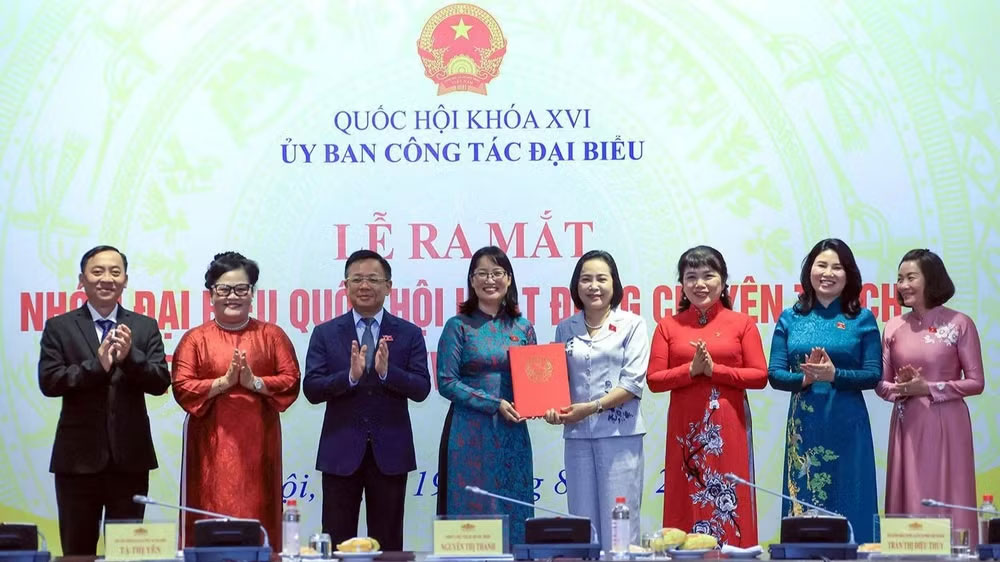 Phó Chủ tịch Quốc hội Nguyễn Thị Thanh trao Nghị quyết của Ủy ban Thường vụ Quốc hội về việc thành lập nhóm đại biểu Quốc hội hoạt động chuyên trách ở địa phương khóa XVI. (Ảnh: TUẤN ANH)
