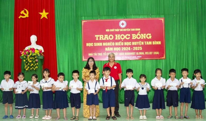 Ông Trần Bá Ninh- Chủ tịch Hội Chữ thập đỏ huyện và bà Nguyễn Thị Thu Hương- Phó Hiệu trưởng Trường THCS TT Tam Bình đại diện tổ chức Phật giáo Cứu trợ toàn cầu trao tặng học bổng cho học sinh cấp tiểu học.