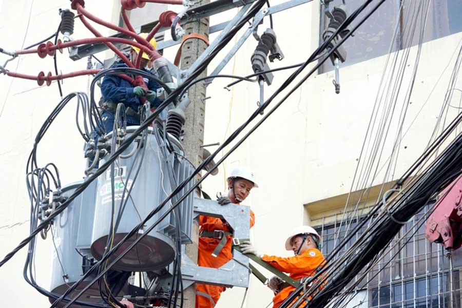 Nhân viên Công ty Điện lực Phú Thọ, TP.HCM bảo trì lưới điện trung thế đảm bảo nguồn điện sinh hoạt cho người dân - Ảnh: HỮU HẠNH