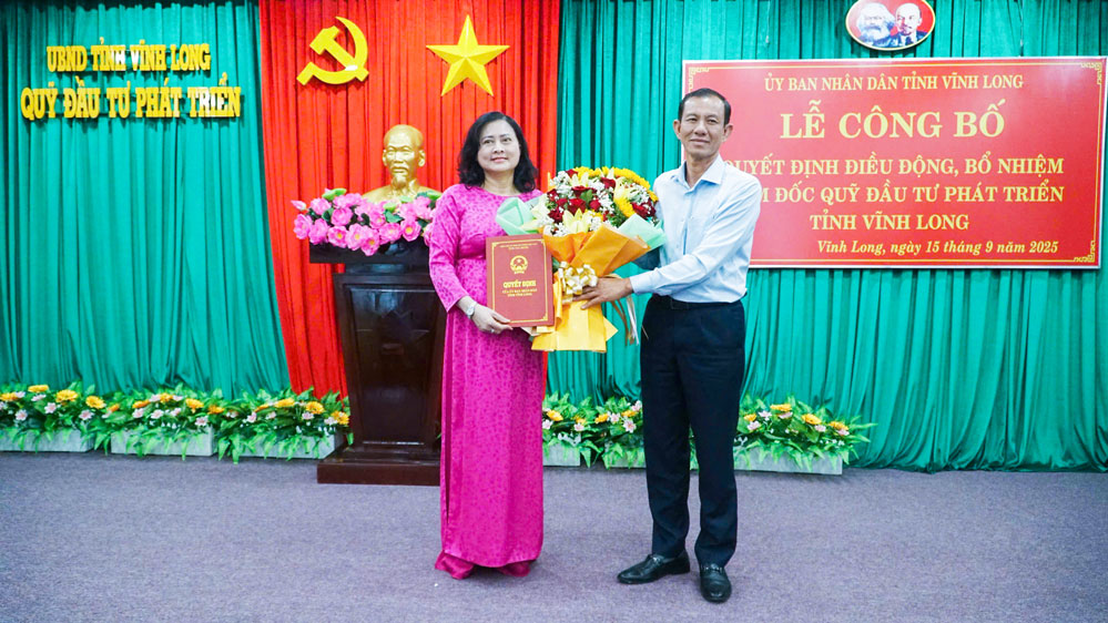 Phó Chủ tịch Thường trực UBND tỉnh- Đặng Văn Chính trao quyết định cho bà Phạm Thị Nở- Giám đốc Quỹ Đầu tư phát triển tỉnh Vĩnh Long.

