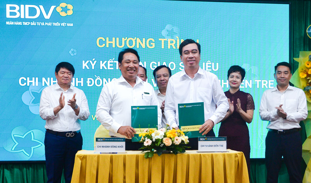 Ông Vũ Thanh Hải - Giám đốc Chi nhánh BIDV Bến Tre và ông Trương Minh Tấn - Giám đốc Chi nhánh BIDV Đồng Khởi ký kết bàn giao số liệu.