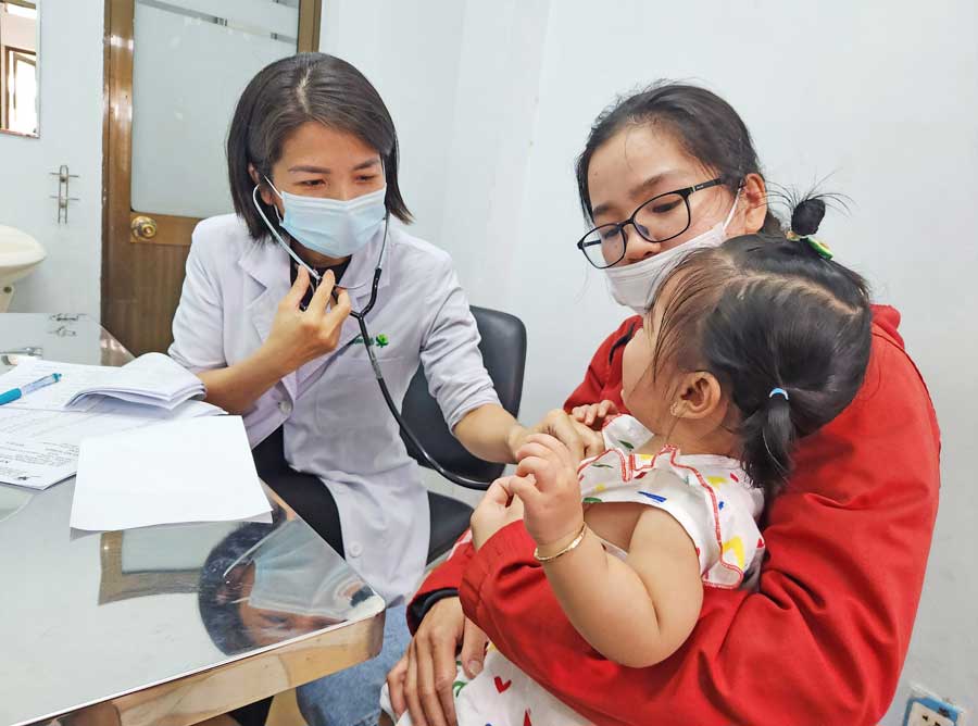 Bác sĩ thăm khám bệnh nhi mắc tay chân miệng tại BVĐK Nguyễn Đình Chiểu.