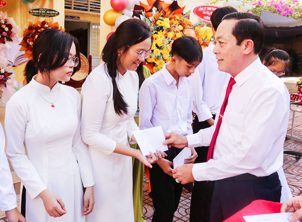 Phó Bí thư Tỉnh ủy- Lâm Minh Đằng tặng học bổng cho học sinh Trường THPT Long Hữu. Ảnh: NGỌC XOÀN
