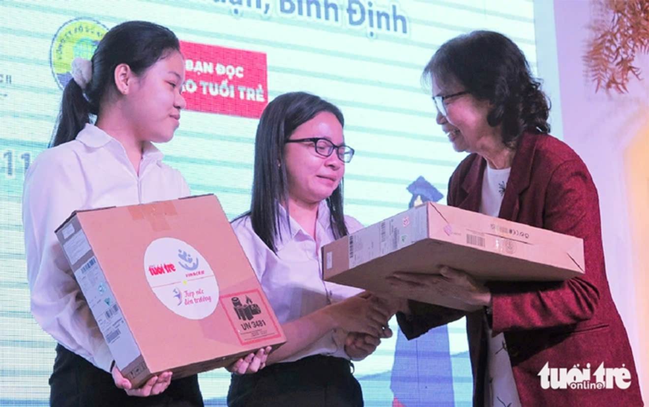 Bà Tiến trao học bổng Tiếp sức đến trường năm 2022 cho tân sinh viên Trần Thị Hiệp (bìa trái) - Ảnh: TRẦN HOÀI