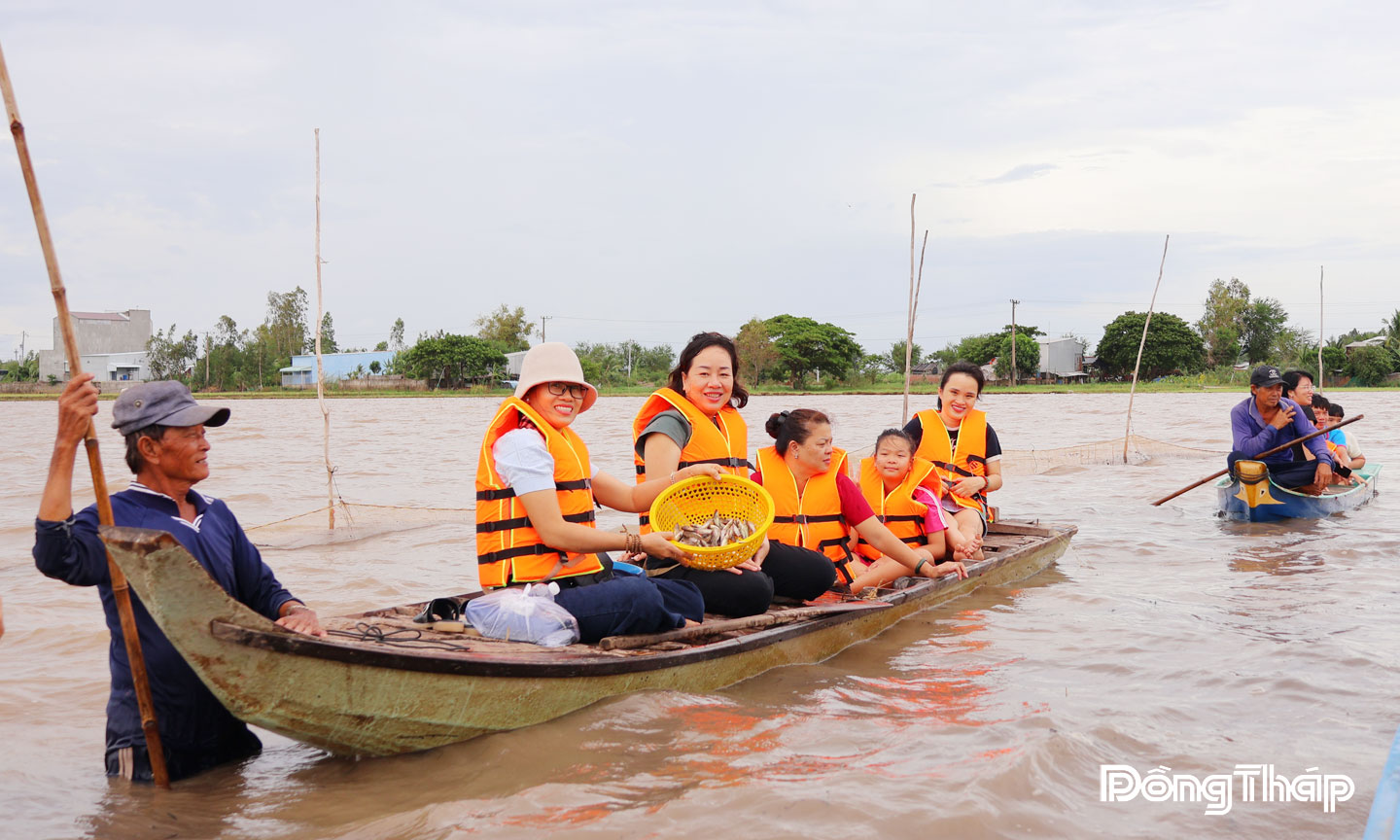 Khách du lịch thích thú trải nghiệm mùa nước nổi tại khu vực nuôi trữ cá đồng ở ấp Giồng Bàng, xã Thường Phước.