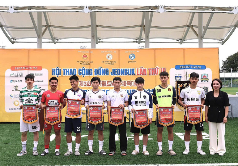 Đại diện Đại sứ quán Việt Nam tại Hàn Quốc trao Cờ kỷ niệm cho đại diện các đơn vị tham gia Hội thao giao lưu thể thao. (Ảnh: TTXVN)